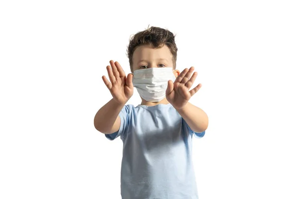 Concepto de cuarentena por coronavirus. Niño con máscara de protección médica durante el virus de la gripe, haciendo un gesto de stop. COVID-19. Pequeño niño blanco haciendo señal de stop con las manos, aislado en blanco —  Fotos de Stock