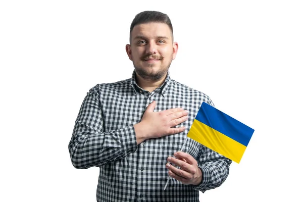 Blanke man met een vlag van Oekraïne en houdt zijn hand op zijn hart geïsoleerd op een witte achtergrond Met liefde voor Oekraïne — Stockfoto