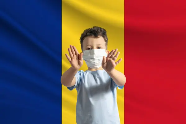 一个戴着防护面具的白人小男孩在罗马尼亚国旗的背景下 用手做一个停车标志 呆在家里罗马尼亚 — 图库照片