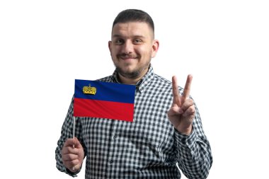 Beyaz adam Lihtenştayn bayrağı taşıyor ve beyaz arka planda izole edilmiş iki parmak gösteriyor..