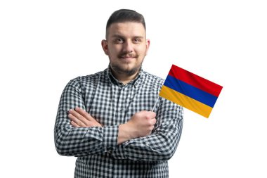 Beyaz adam Ermenistan bayrağını taşıyor. Beyaz bir arka planda kollarını kavuşturup gülümsüyor..