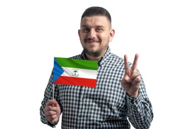Beyaz adam elinde Ekvator Ginesi bayrağı tutuyor ve beyaz arka planda izole edilmiş iki parmak gösteriyor..