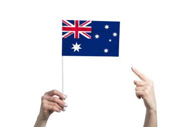 Güzel bir kadın eli Avustralya bayrağını tutuyor ve beyaz arka planda izole bir şekilde diğer elinin parmağını gösteriyor..