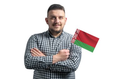 Beyaz adam beyaz bir arka planda kolları çaprazlanmış bir şekilde gülümseyen Belarus bayrağı taşıyor..