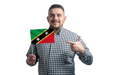 Beyaz adam St. Kitts ve Nevis bayrağını tutuyor ve diğer elini beyaz arka planda izole edilmiş bayrağa doğrultuyor..