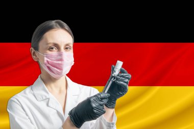 Kız doktor, Almanya bayrağının arka planına karşı aşı hazırlıyor. Aşı kavramı Almanya.