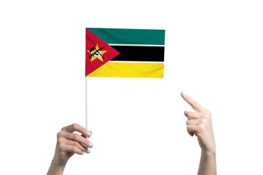 Güzel bir kadın eli, beyaz arka planda izole edilmiş diğer elinin parmağını gösterdiği bir Mozambik bayrağını tutuyor..