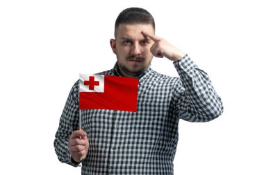 Tonga bayrağı taşıyan beyaz bir adam ve beyaz bir arka planda izole edilmiş bir şekilde parmağıyla şakağına dokunuyor..