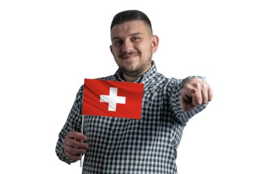 Elinde İsviçre bayrağı olan beyaz bir adam beyaz bir arka planda yalnız başına önünü işaret ediyor..