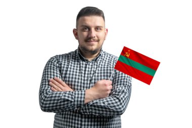 Elinde Transnistria bayrağı olan beyaz bir adam beyaz bir arka planda kollarını kavuşturarak gülümsüyor..