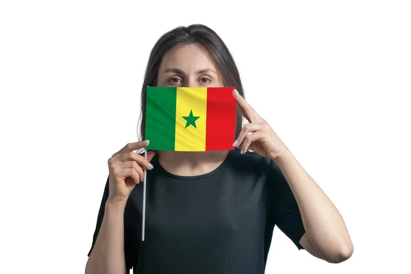 快乐的年轻白人妇女举着塞内加尔国旗 用白色的背景遮住她的脸 — 图库照片