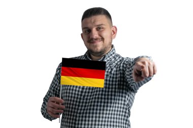 Elinde Almanya bayrağı olan beyaz bir adam beyaz bir arka planda yalnız başına önünü işaret ediyor..