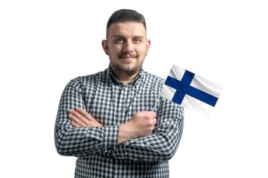 Beyaz adam elinde Finlandiya bayrağı, beyaz bir arka planda kollarını kavuşturarak gülümsüyor..