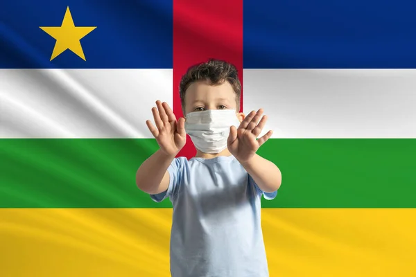 中央アフリカ共和国の旗の背景に保護マスクの小さな白い少年 彼の手で停止記号を作ります 家に滞在中央アフリカ共和国 — ストック写真