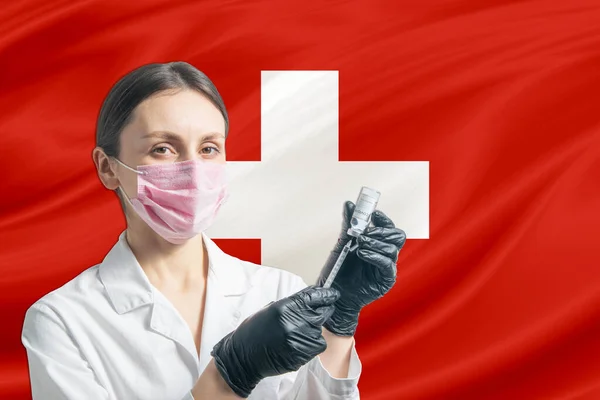Girl doctor prepares vaccination against the background of the Switzerland flag. Vaccination concept Switzerland.