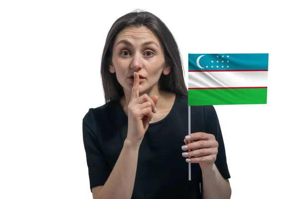 ウズベキスタンの国旗を持ち 唇に指を差し伸べる幸せな若い白人女性 — ストック写真