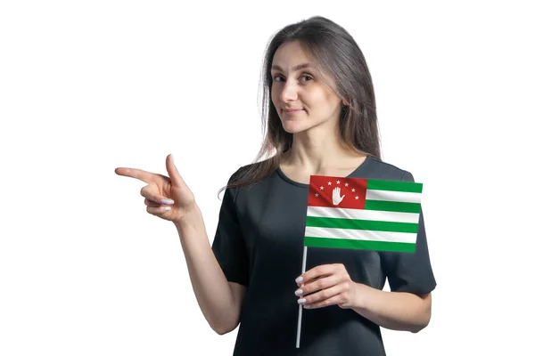 Szczęśliwa Młoda Biała Kobieta Trzyma Flagę Abchazja Wskazuje Lewo Odizolowany — Zdjęcie stockowe