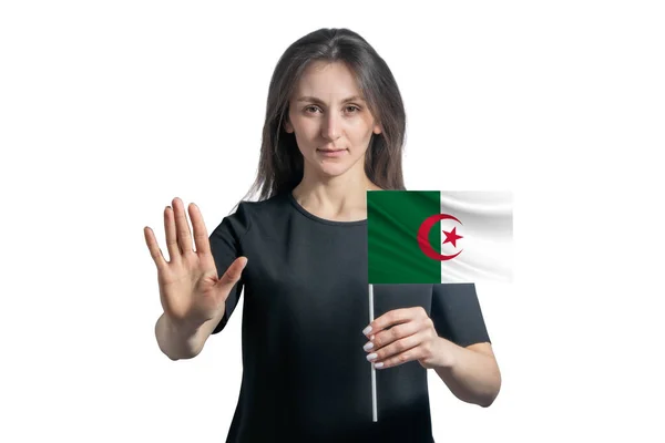 幸せな若い白い女性はアルジェリアの旗を持ち 深刻な顔をして白い背景に孤立した手を停止記号を示しています — ストック写真