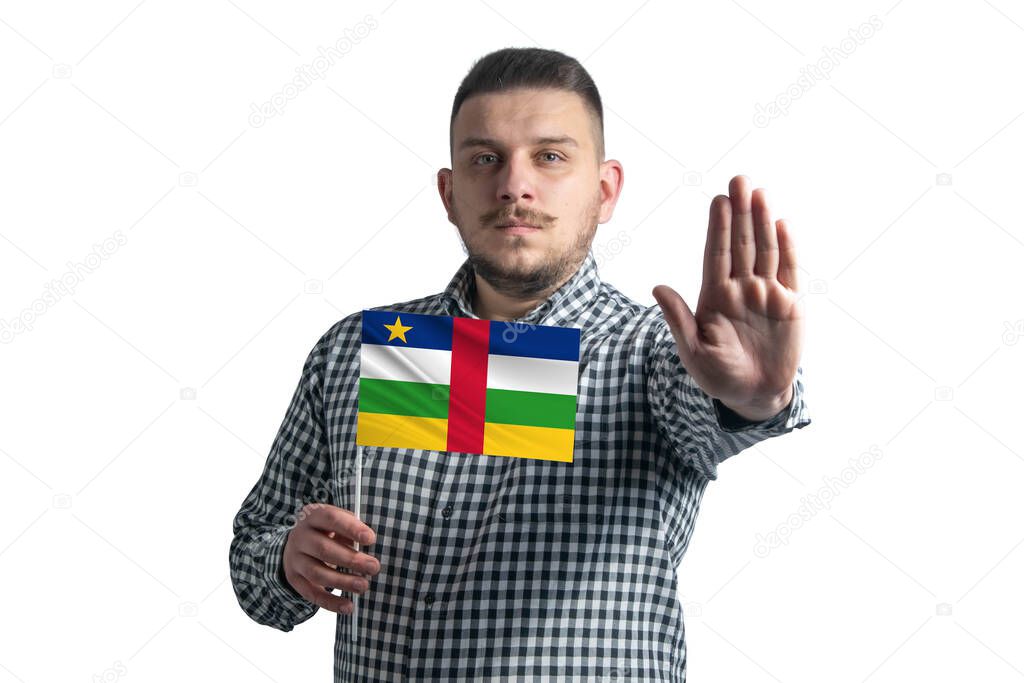 White guy holding a flag of Central African Republic and with a serious face shows a hand stop sign isolated on a white background.