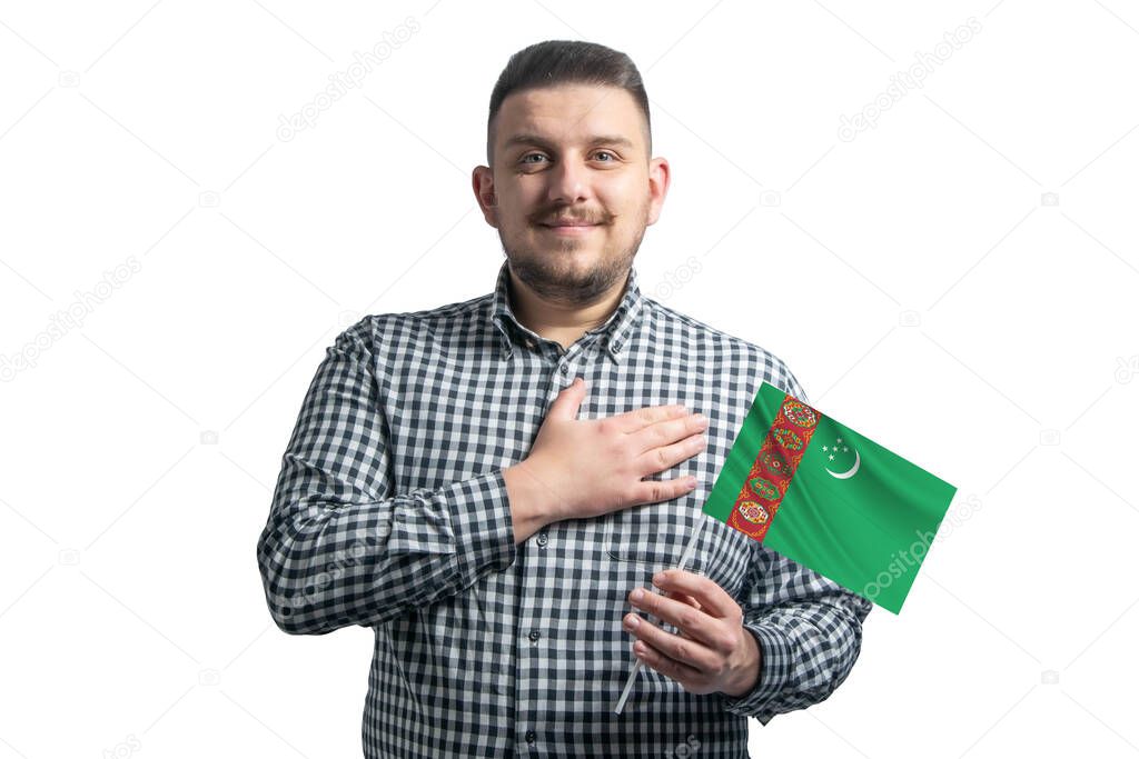 White guy holding a flag of Turkmenistan and holds his hand on his heart isolated on a white background With love to Turkmenistan.
