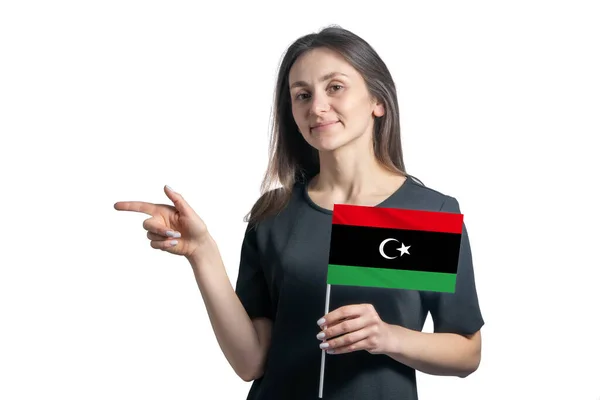 Szczęśliwa Młoda Biała Kobieta Trzyma Flagę Libii Wskazuje Lewicę Białym — Zdjęcie stockowe