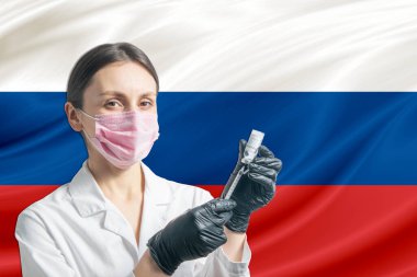 Girl doctor prepares vaccination against the background of the Russia flag. Vaccination concept Russia.