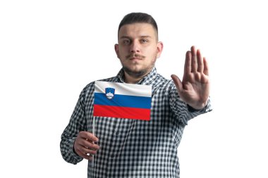 White guy holding a flag of Slovenia and with a serious face shows a hand stop sign isolated on a white background.
