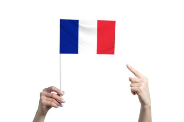 Güzel bir kadın eli, beyaz arka planda izole edilmiş diğer elinin parmağını gösterdiği bir Fransa bayrağını tutuyor..
