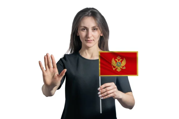 快乐的年轻白人女人举着黑山的国旗 严肃的脸上挂着一个白色背景的手势 — 图库照片