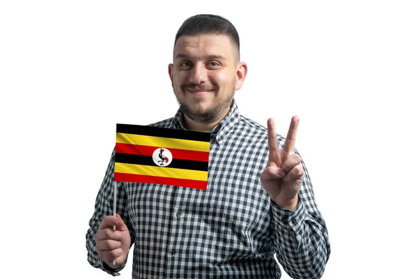 拿着乌干达国旗的白人在白色背景上伸出两根手指 — 图库照片