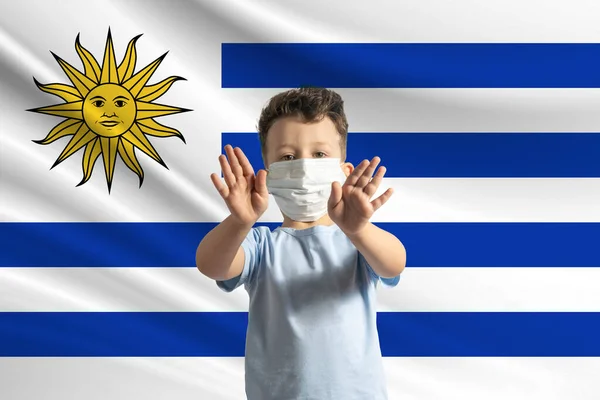 Liten Vit Pojke Skyddande Mask Bakgrunden Flaggan Uruguay Gör Stoppskylt — Stockfoto