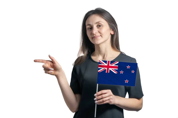 ニュージーランドの国旗を掲げた幸せな若い白人女性が白い背景に孤立した左側を指しています — ストック写真