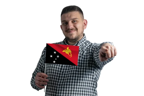 パプアニューギニアの旗を持ち 白い背景に孤立した彼の前で前方を指す白人 — ストック写真