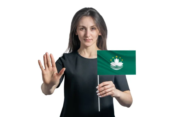 マカオの旗を掲げる幸せな若い白人女性と深刻な顔は白い背景に孤立した手を停止記号を示しています — ストック写真