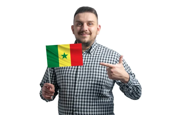 拿着塞内加尔国旗的白人把另一只手的手指指向被白色背景隔开的国旗 — 图库照片