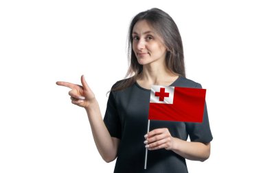 Tonga bayrağını tutan mutlu beyaz kadın ve beyaz arka planda izole edilmiş solu işaret ediyor..