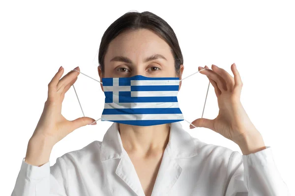 带希腊国旗的呼吸机医生戴上医疗面罩 隔离在白色背景下 图库照片