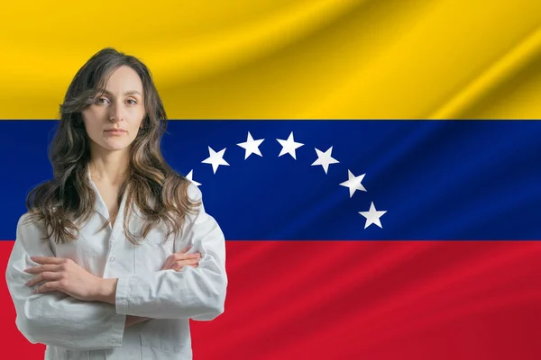 委内瑞拉的医学 站在委内瑞拉国旗的背景下 身穿军大衣 手挽手站在那里 快乐而美丽的女医生 — 图库照片
