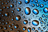 Barevné kapky vody na hladký skleněný povrch