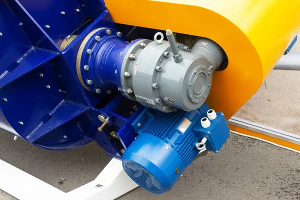Engine close up. Electric motor with transmission gear covered with blue paint, detailed close up. Maintenance concept. Starter or generator equipment
