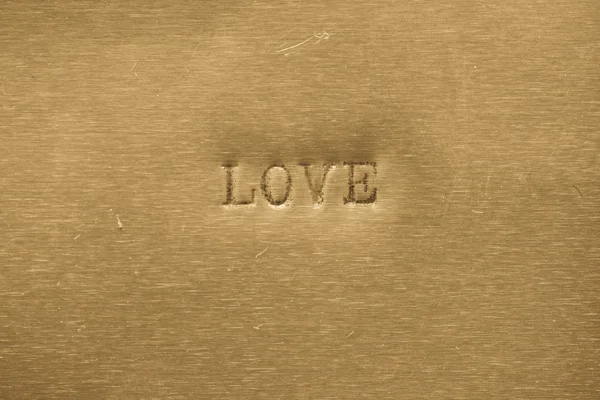 Słowo miłość drukowane na tle metalowe — Zdjęcie stockowe