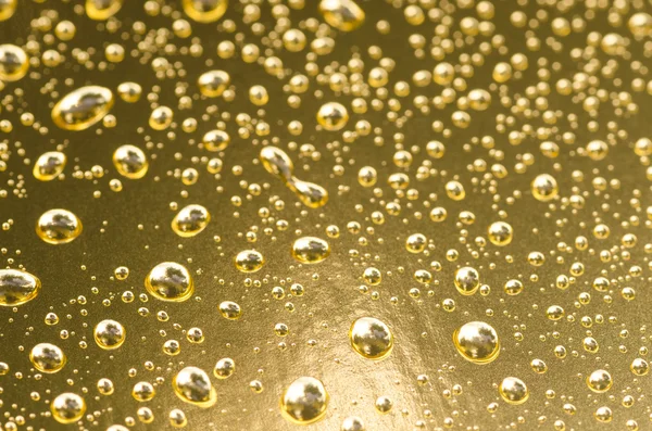 Wassertropfen auf goldenem metallischen Hintergrund — Stockfoto