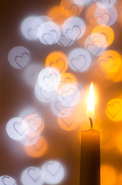 Candle on heart shapes background — Stock Photo, Image