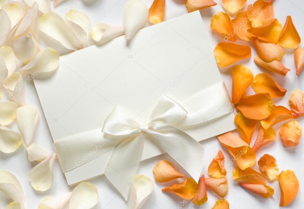 card with ribbon and rose petals 