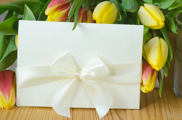 Тюльпани та біла паперова картка — стокове фото