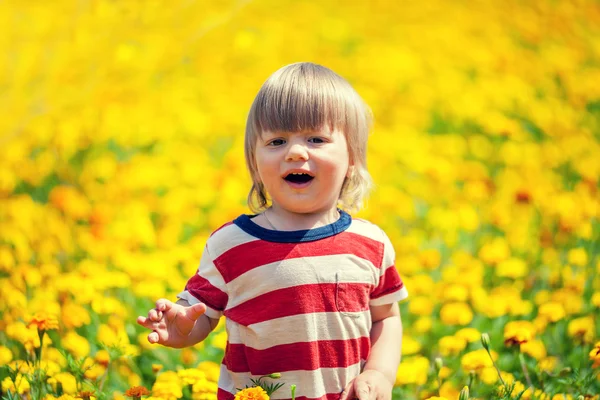 Junge, der in Blumen geht — Stockfoto