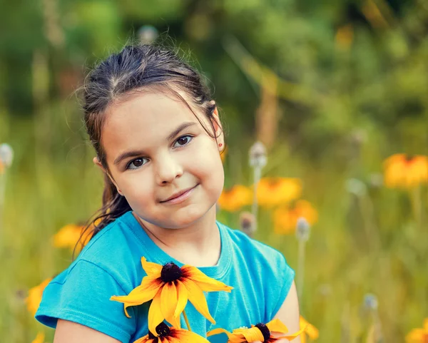 Little girl walking on the flower meadow — Stock Photo, Image