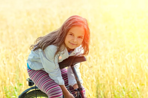 Menina na bicicleta velha no campo — Fotografia de Stock