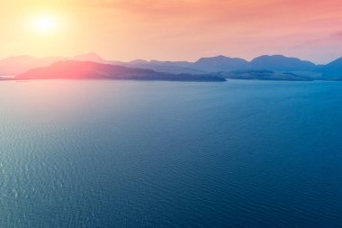 Ufuktaki ada. Denizde kayalar. Akşamları güzel kayalık deniz manzarası. Norveç 'in vahşi doğası. Lofoten adaları deniz manzarası. Gradyan rengi