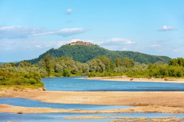 Güneşli bir günde dağ nehri. Doğa manzarası. Dağdaki Khust Kalesi 'nin kalıntıları. Tisza Nehri, Khust, Zakarpattia Oblastı, Ukrayna